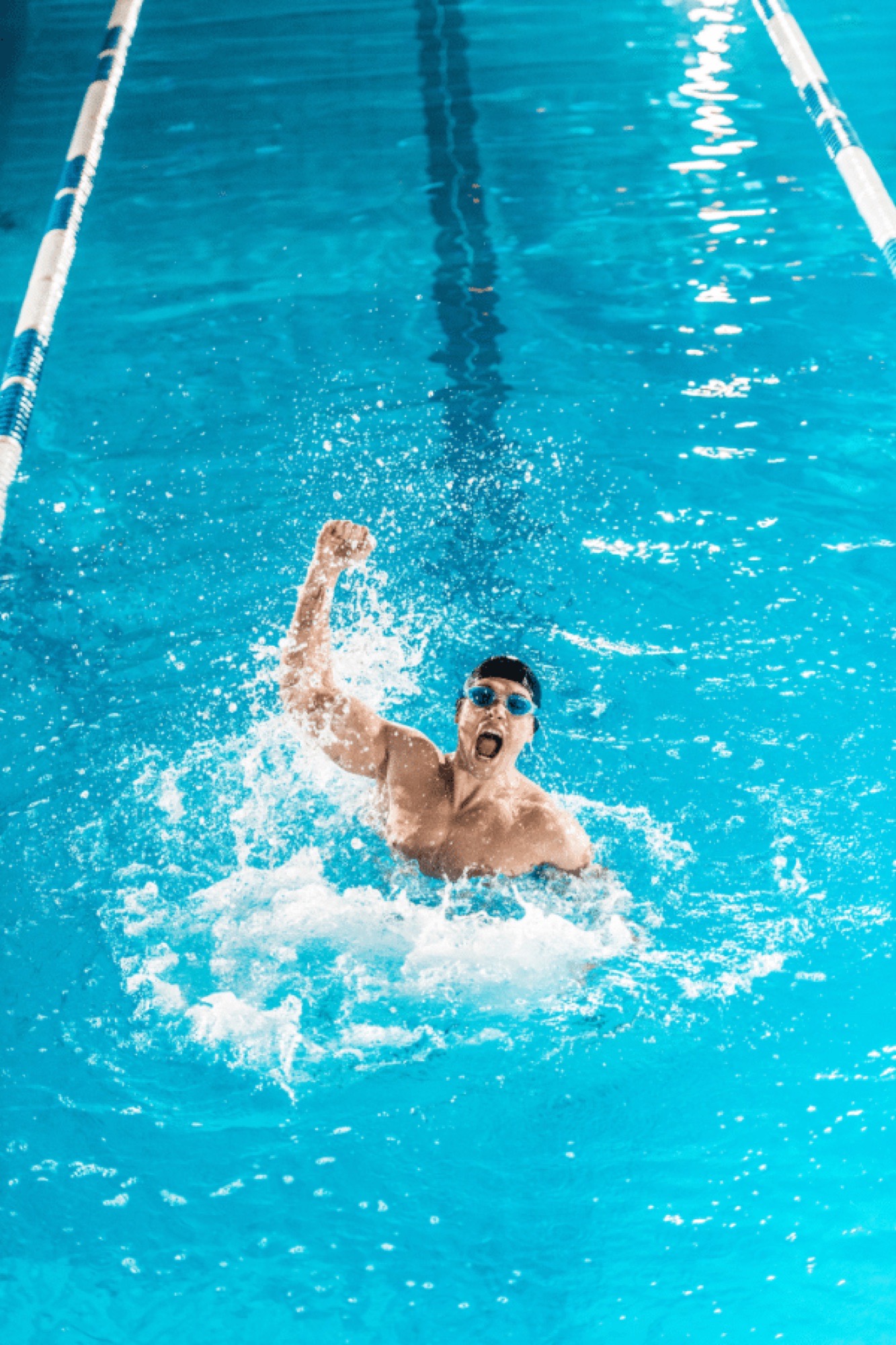 Schwimmer jubelt mit erhobener Faust im Becken