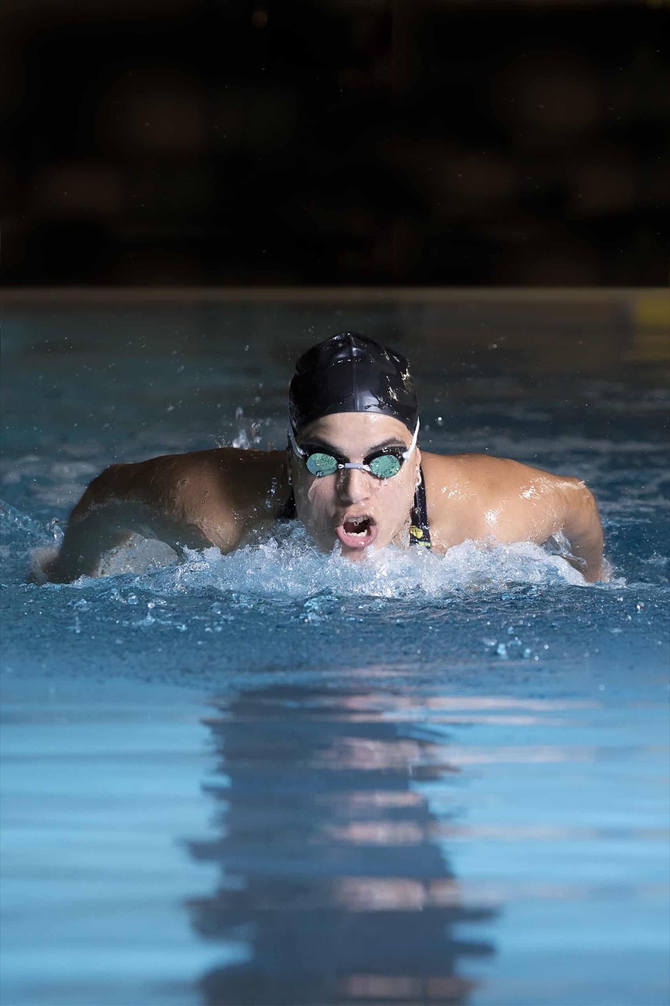 Schwimmerin beim Delfinschwimmen in dramatischem Licht